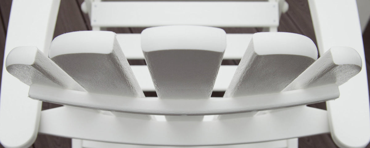 An overhead view shows the top of a white Adirondack chair's headrest, arms, and seat.